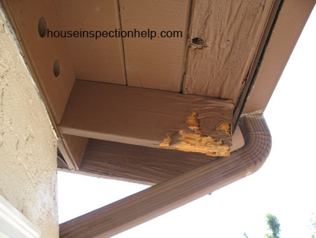 underside of brown wood roof overhang with water damage